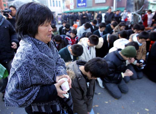 韩国首尔市中心一大学学业能力测试的考场前,一位老师与她的学生一起祈祷他们考试顺利。(图片来源:东方网) 韩国首尔市中心一大学学业能力测试的考场前,一位老师与她的学生一起祈祷他们考试顺利。(图片来源:东方网)